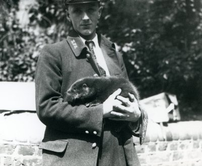 Verzorger Leslie Martin Flewin wiegt een otterjong in zijn armen in de Londense Zoo, juni 1922 door Frederick William Bond